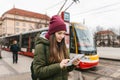 Beautiful tourist girl with a tablet on a street in Prague looks at a map or uses the Internet or a mobile application. Royalty Free Stock Photo