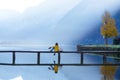 Tourist girl in a hat and with a backpack sitting on a wooden bridge Royalty Free Stock Photo