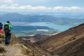 Girl tourist hiker looking at view of lake Rotoaira and lake Taupo from Tongariro Alpine Crossing hike with clouds above
