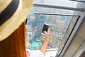 Girl tourist with mobile phone by the window of skyscraper of th Royalty Free Stock Photo