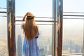 Girl tourist with mobile phone by the window of skyscraper of th Royalty Free Stock Photo