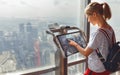 Girl tourist with monitor of computer at window of skyscraper Royalty Free Stock Photo