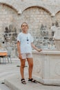 Girl Tourist Resting in the Ancient Narrow Street On A Beautiful Summer Day In MEDITERRANEAN MEDIEVAL CITY, OLD TOWN Royalty Free Stock Photo