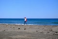 A girl tourist stands on the seashore with a backpack on a sunny day and takes a selfie. Concept tourism and recreation