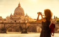 Girl tourist takes photo of St Peter`s Basilica, Rome, Italy, Europe