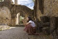 Girl tourist takes a picture at the Abbey of Orval, in Belgium. Ruins of the Cistercian monastery and the Gothic church