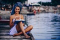 Girl with a towel on her head reading a book while sitting on the beach Royalty Free Stock Photo