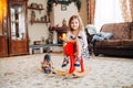 Girl on a toy horse at home Royalty Free Stock Photo