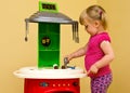 Girl and toy kitchen Royalty Free Stock Photo