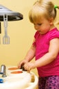 Girl and toy kitchen Royalty Free Stock Photo