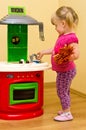 Girl and toy kitchen Royalty Free Stock Photo