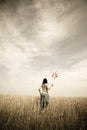 Girl with toy wind turbine at field