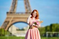 Girl with traditional French bread baguette and flowers in front of the Eiffel tower Royalty Free Stock Photo