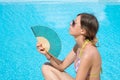 Girl with a traditional hand fan by the pool Royalty Free Stock Photo