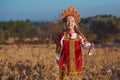 Girl in traditional russian costume and headdress adorable smiling and laughting in field