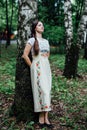 Girl in traditional Russian dress sarafan leaned against birch Royalty Free Stock Photo