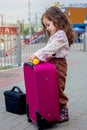 Girl with the travel case on the railway station ready to travel.