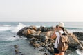 Girl traveler with a backpack and camera on the beach. Royalty Free Stock Photo