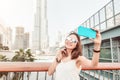 Girl traveler and blogger takes selfie photo in Dubai, United Arab Emirates