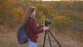 Girl traveler with a camera takes beautiful photos of nature. Young independent female tourist photographer, photographs Royalty Free Stock Photo