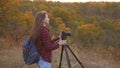 Girl traveler with a camera takes beautiful photos of nature. Young independent female tourist photographer, photographs Royalty Free Stock Photo