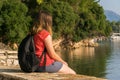 Girl traveler, enjoys the view of the sea, rocks, conifers