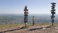 Girl traveler in a light summer dress standing on mount Mashuk and studying the distance signs