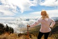 Girl is a traveler in a mountain trek. A view from above on mountains and clouds Royalty Free Stock Photo