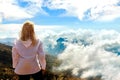 Girl is a traveler in a mountain trek. A view from above on mountains and clouds. Above the clouds. Trekking to Rinjani volcano. Royalty Free Stock Photo