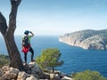 Girl traveler overwatching bay. Mountain trail along west shore