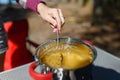 Girl traveler prepares food on portable gas stove, on a folding table on the background of camping in forest. Women's hands inter Royalty Free Stock Photo