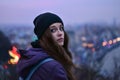 Girl traveler standing in front of winter evening cityscape