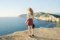 Girl traveler standing on the mountain top and looking at sea Royalty Free Stock Photo