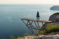 A girl traveler stands on the edge of a cliff on the bridge Royalty Free Stock Photo