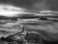 Girl traveler stands on top of mountain holding strong light Royalty Free Stock Photo