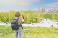 The girl traveler takes pictures of the sights of Moscow. Young woman with a backpack and a camera. Kremlin and Zaryadye Park.