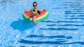 Girl travelling. Young sexy woman with inflatable rubber ring in bikini swimsuit, sunglasses swim in blue pool water Royalty Free Stock Photo