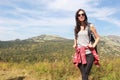 The girl travels through the mountains. Stylish hipster female traveler with a backpack. Royalty Free Stock Photo