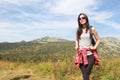 The girl travels through the mountains. Stylish hipster female traveler with a backpack. Royalty Free Stock Photo