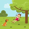 Girl on a tree swing in the park and a dog Royalty Free Stock Photo