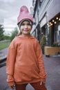 Girl in trendy hats and hoodie having fun in park, fall vibes, autumn beauty style, child fashion