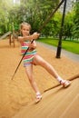 Girl tries to climb on wooden construction