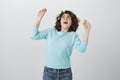 Girl tries to protect herself from pouring water. Portrait of terrified shocked attractive caucasian female, raising