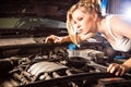 Girl tries to repair broken car