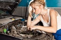 Girl tries to repair broken car