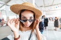 girl trying on hilarious stylish sunny gangsta glasses in a store. Humor style concept