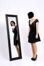 Girl trying on short dress and looking at herself  in the mirror Royalty Free Stock Photo