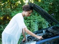 Girl is trying to repair a broken car Royalty Free Stock Photo