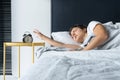 The girl turns off the annoying alarm clock to continue sleeping. Get some more sleep. It is a hard morning. Time to wake up Royalty Free Stock Photo