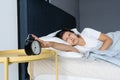 The girl turns off the annoying alarm clock to continue sleeping. Get some more sleep. It a hard morning. Time to wake up Royalty Free Stock Photo